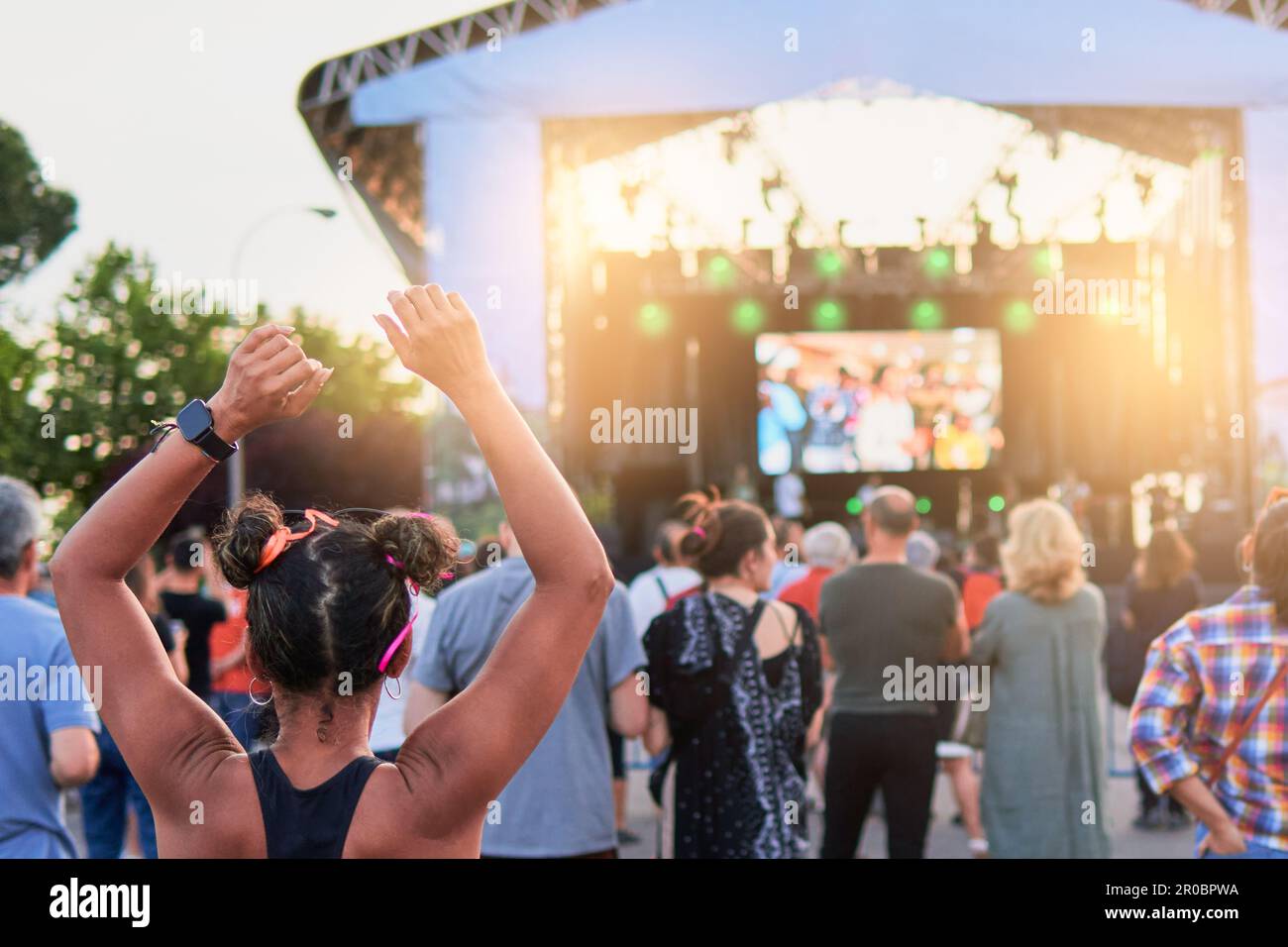 Les gens attendent un festival de musique d'été pour commencer devant la scène au coucher du soleil Banque D'Images