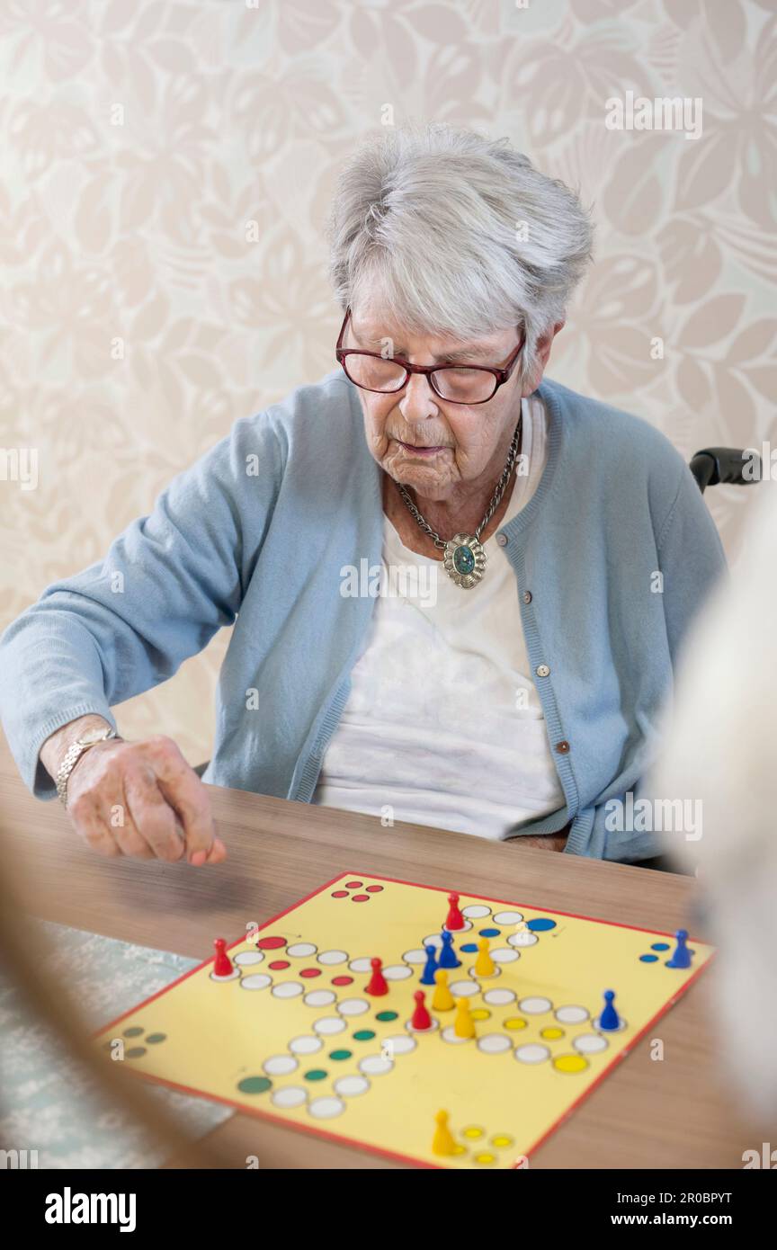 Femme senior jouant ludo jeu de société dans le repos à la maison Banque D'Images