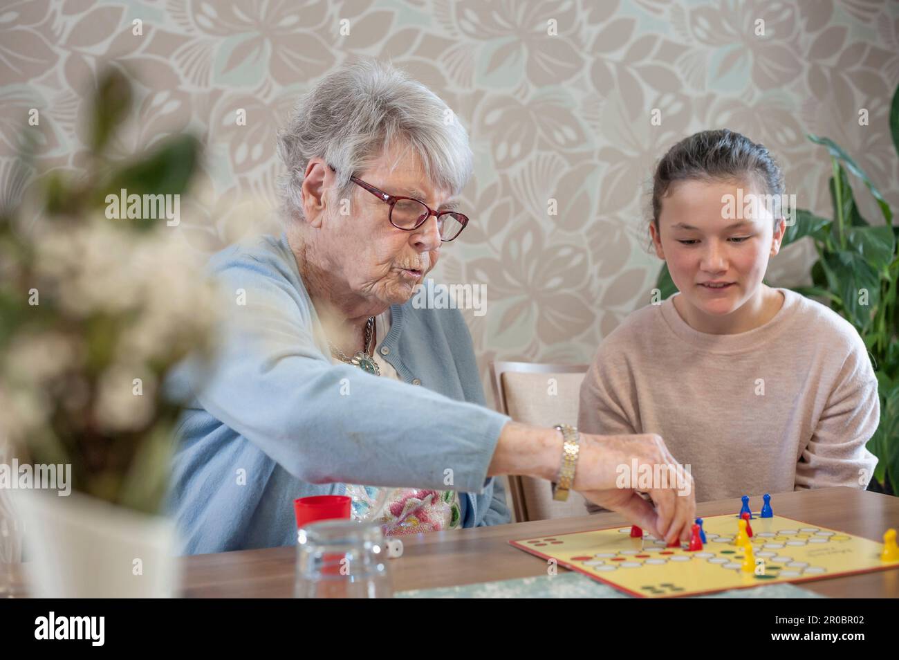 Fille jouant ludo jeu de société avec des femmes âgées dans la maison de repos Banque D'Images