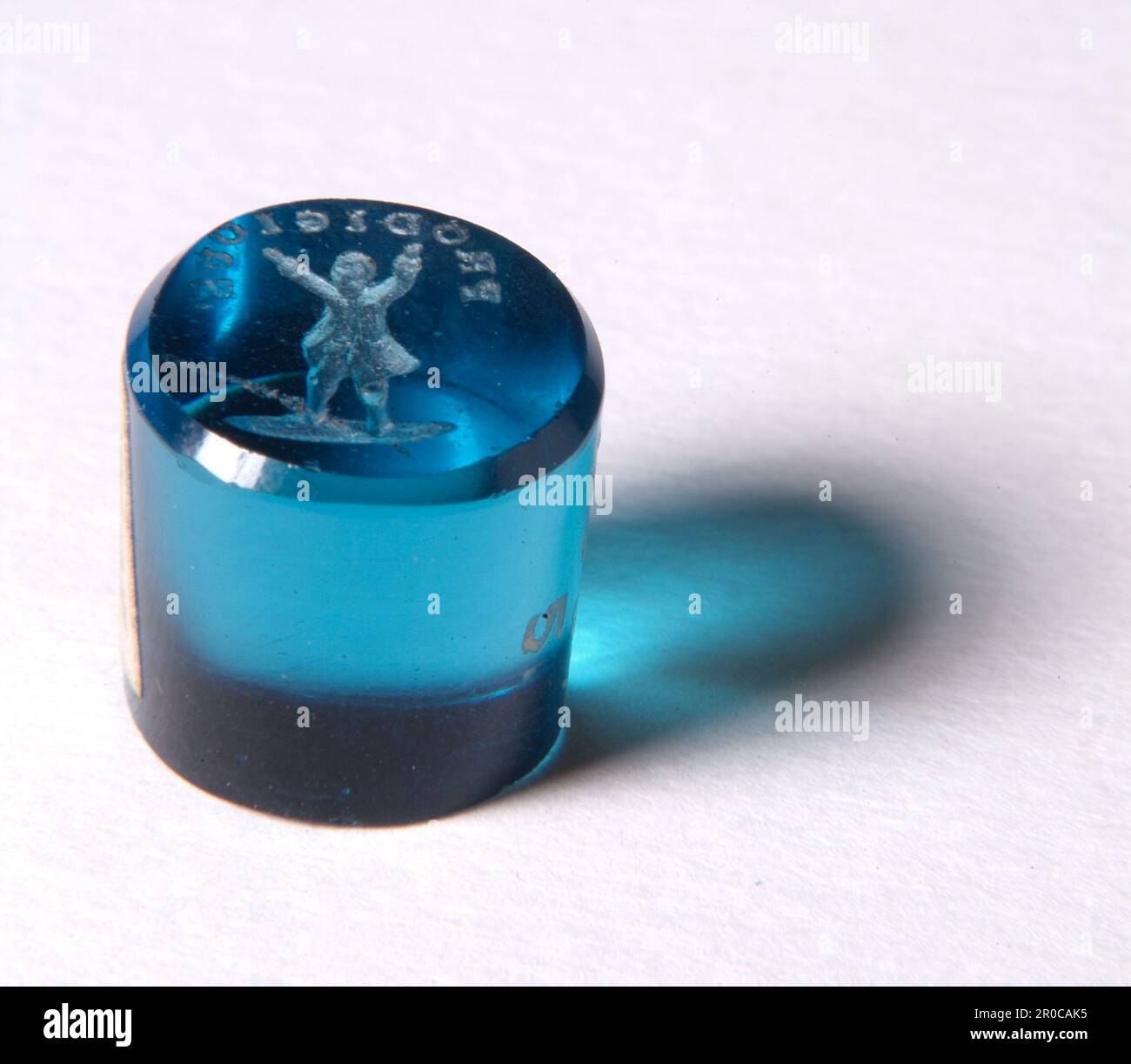 Matrice signet - matrice de sceau, 1750-1800. Peut-être fabriqué à Birmingham 1 présenté par Francis Buckley, 1934.. Un "allumage" ou "matrice de joint" est un petit timbre utilisé pour l'empreinte de la marque de son propriétaire en cire sur des documents. Il s'agit d'une collection de vingt-sept acquis par le musée en 1934. La majorité des exemples sont finement faits de verre translucide moulé, dans ce cas bleu translucide. Plusieurs inscriptions portent gravées en sens inverse, comme dans le cas de cet exemple. Le mot « PRODIGIEUX » et la conception d'une figure masculine avec des bras levés ont peut-être eu une signification particulière à l'époque. Banque D'Images