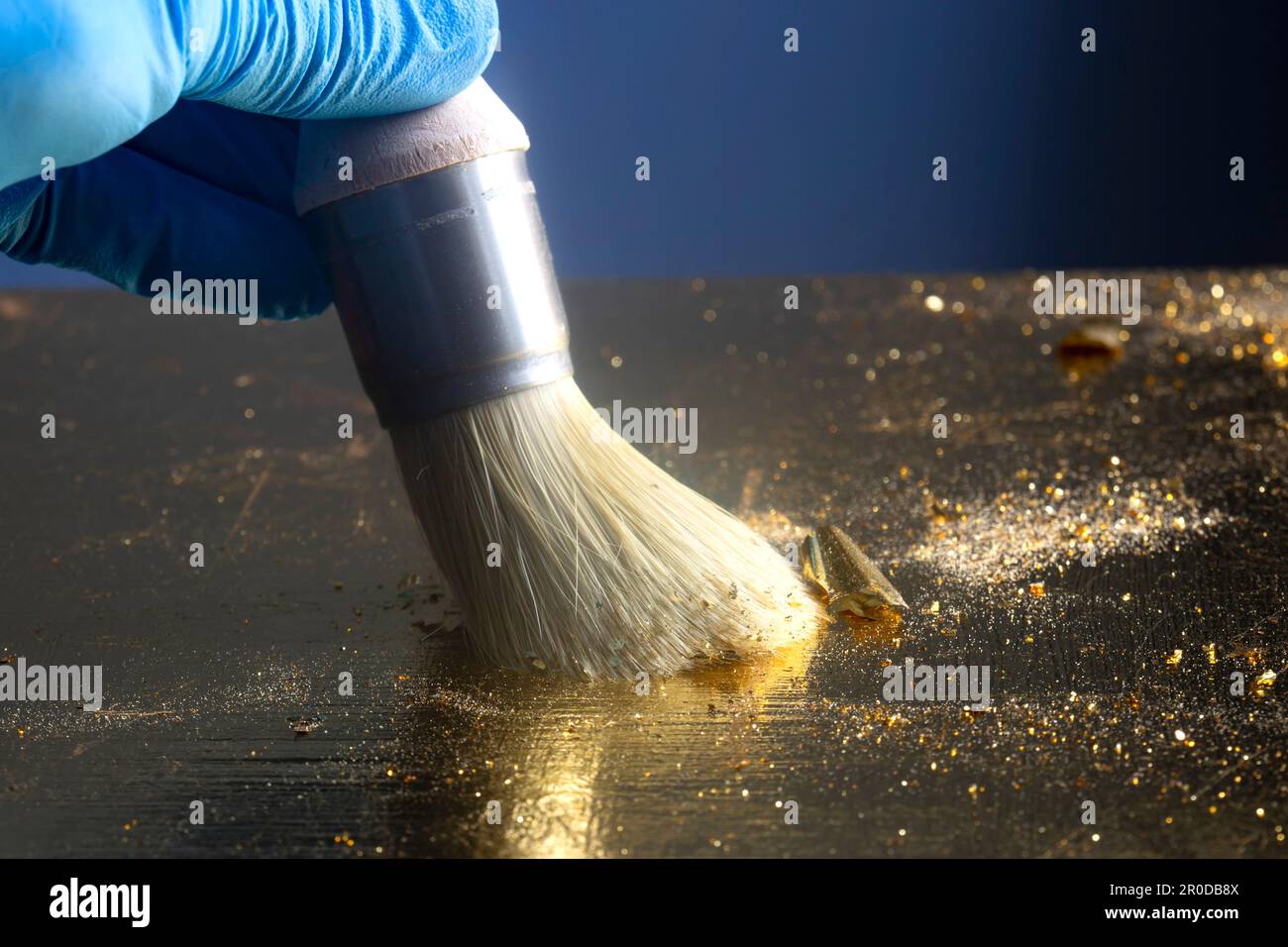 Personne dorant un plateau de table en bois avec des feuilles d'or et un pinceau. Concept d'artisanat d'aménagement. Banque D'Images
