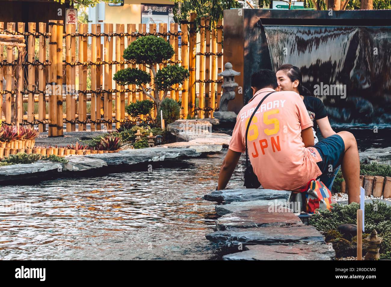 KANCHANABURI -THAÏLANDE, 30 MARS 2023 : touristes non identifiés viennent visiter et nourrir koi ou carpe fantaisie dans un petit étang avec beau jardin décoré Banque D'Images