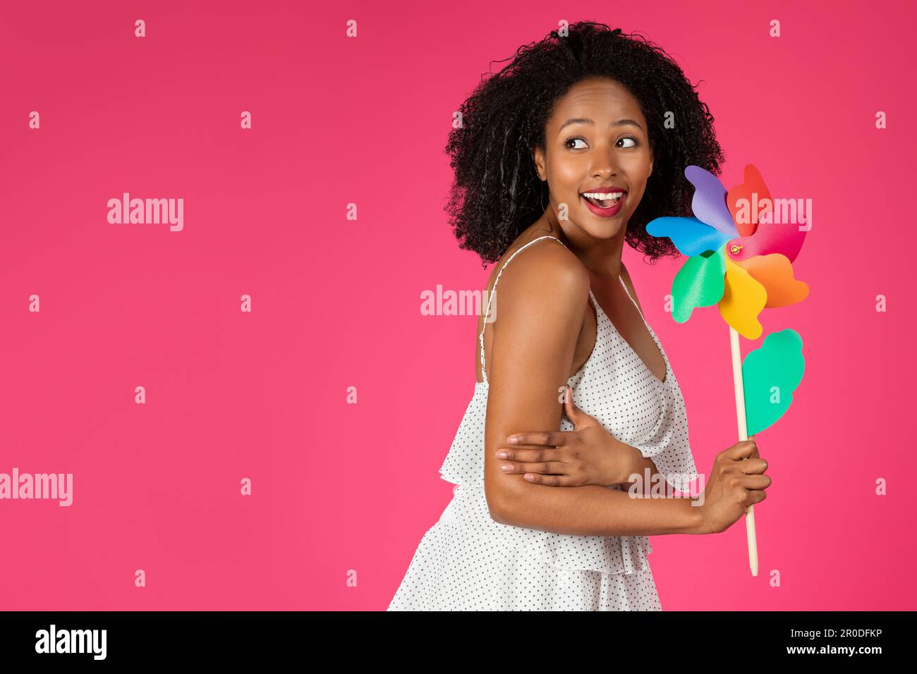 Gai mignon jeune afro-américaine curly femme avec fleur de moulin à vent profiter de temps libre, vacances Banque D'Images