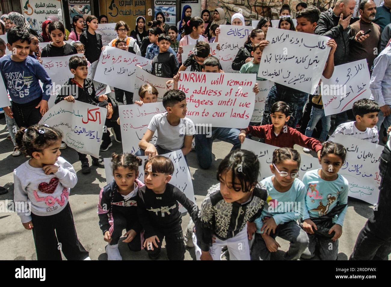 Naplouse, Palestine. 08th mai 2023. Les enfants palestiniens tiennent des écriteaux devant le siège de l'Office de secours et de travaux des Nations Unies (UNRWA) dans le camp de réfugiés d'Askar, demandant la fourniture de services, l'ouverture de centres de santé et d'écoles. (Photo de Nasser Ishtayeh/SOPA Images/Sipa USA) crédit: SIPA USA/Alay Live News Banque D'Images