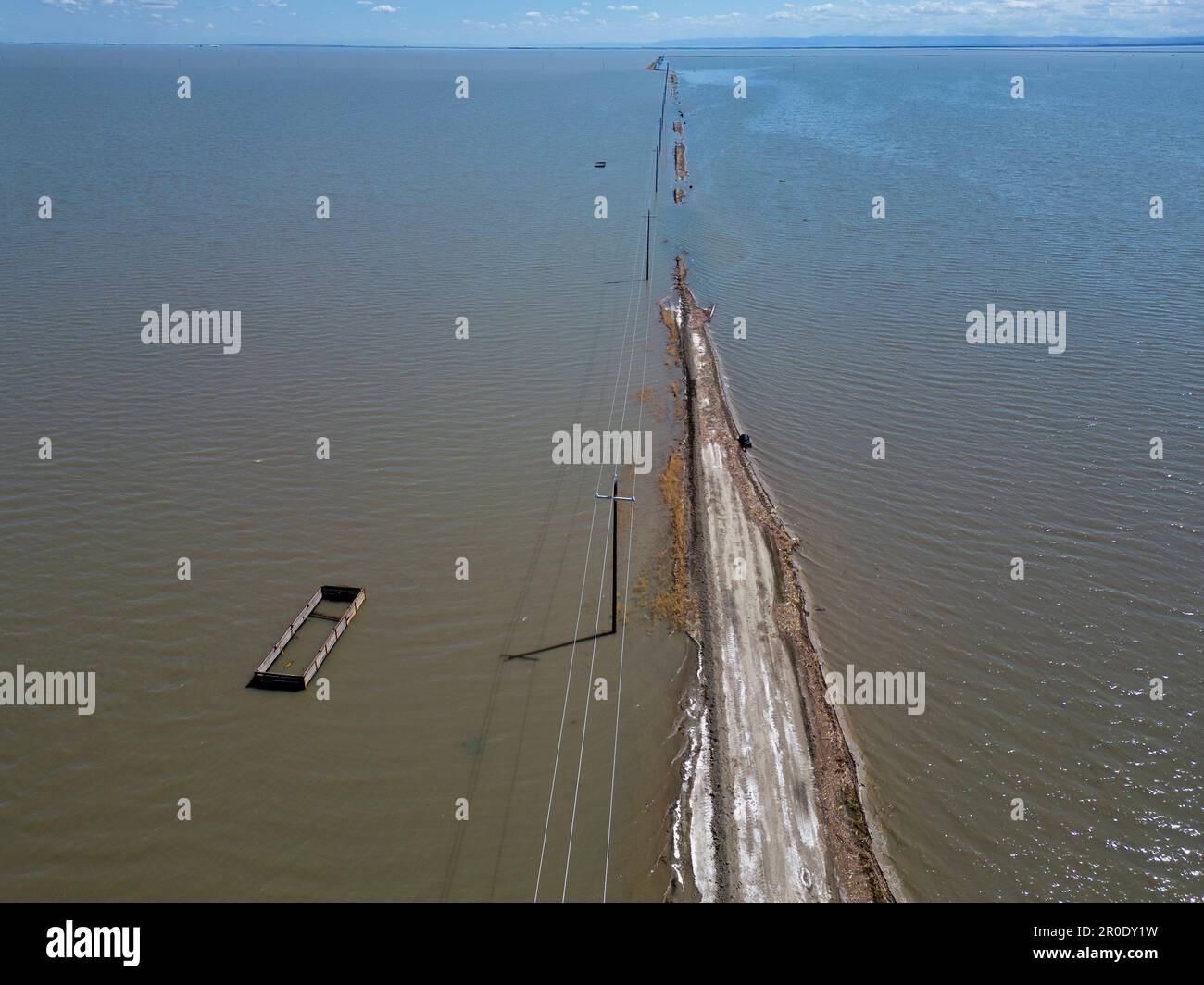 Une route de terre est consommée par les eaux montantes du lac Tulare pendant l'inondation de 2023 dans la vallée centrale de Californie Banque D'Images