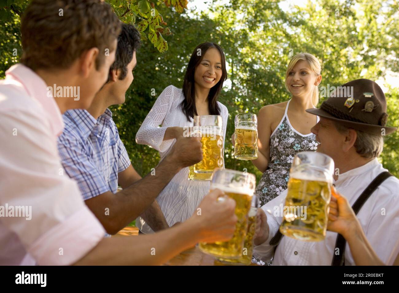 Personnes avec des steins de bière dans le jardin de bière, Munich, Bavière Banque D'Images