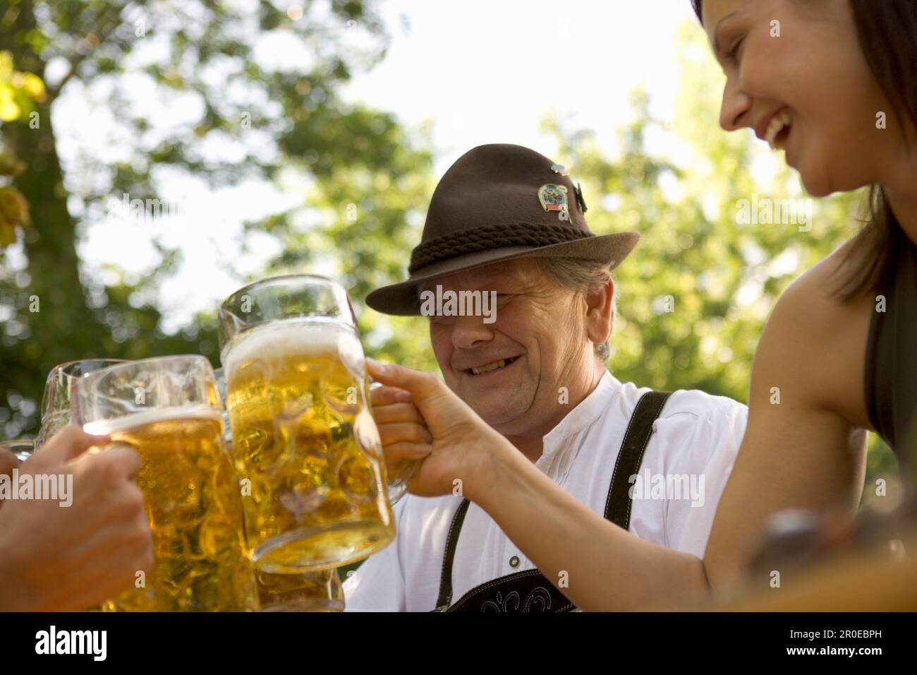 Un homme bavarois plus âgé et une jeune femme qui se toasque, Munich, Bavière Banque D'Images