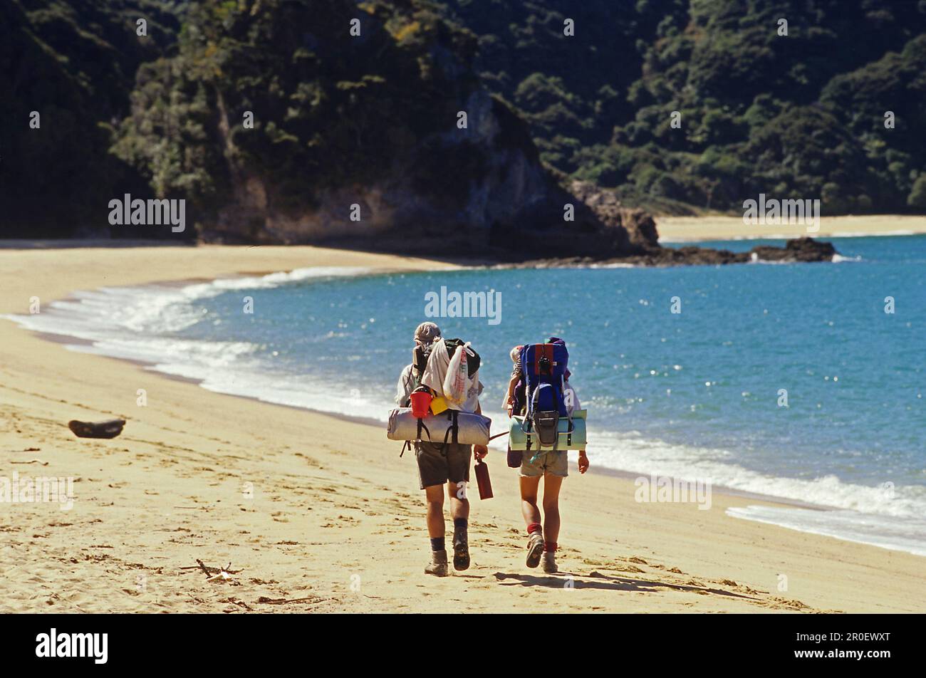 Randonneurs avec sac à dos sur la plage au soleil, Abel Tasman Coast Track, parc national d'Abel Tasman, Nouvelle-Zélande, Océanie Banque D'Images