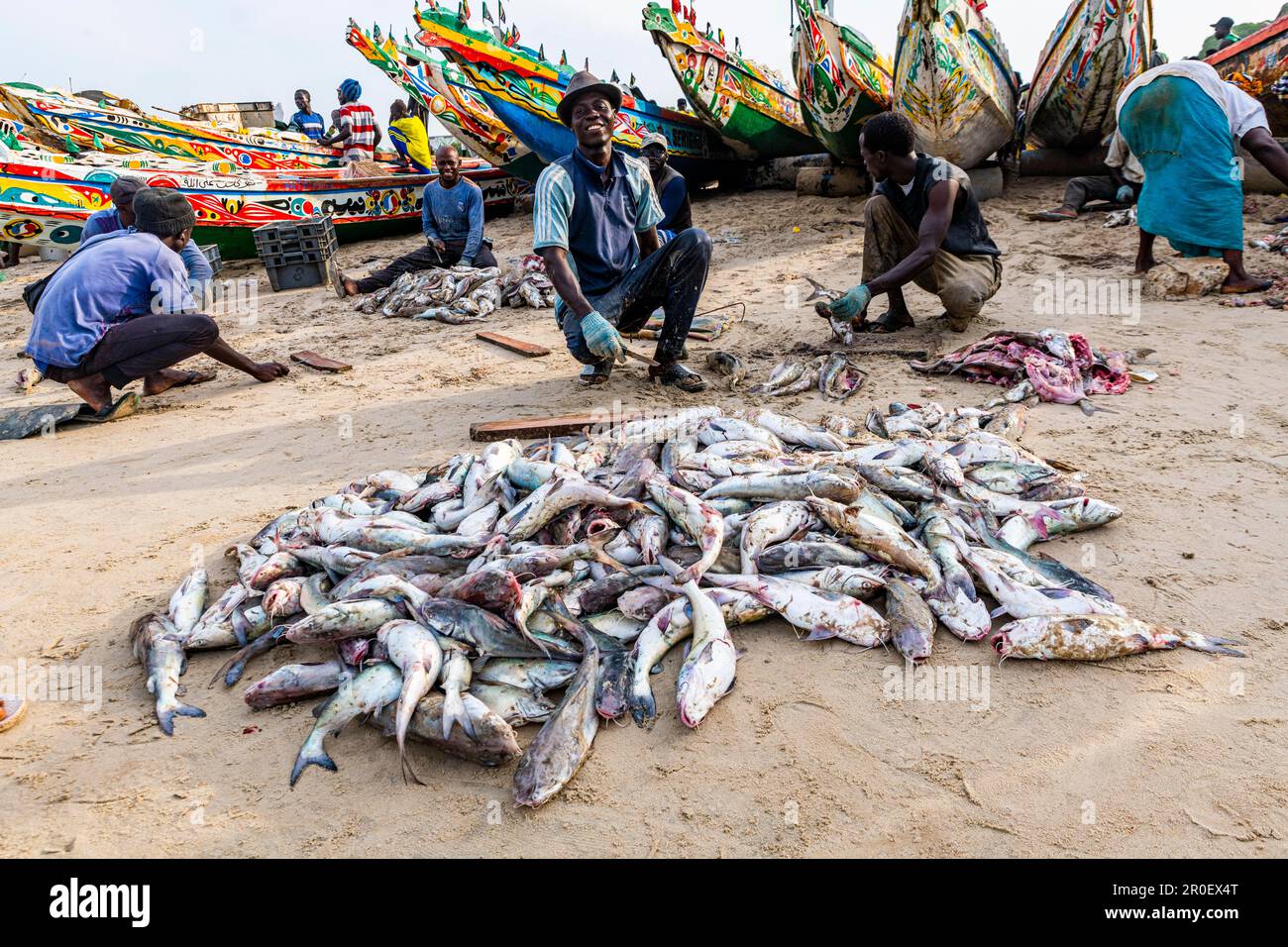 Pêcheurs avant les bateaux de pêche colorés, Cap Skirring, Casamance, Sénégal Banque D'Images