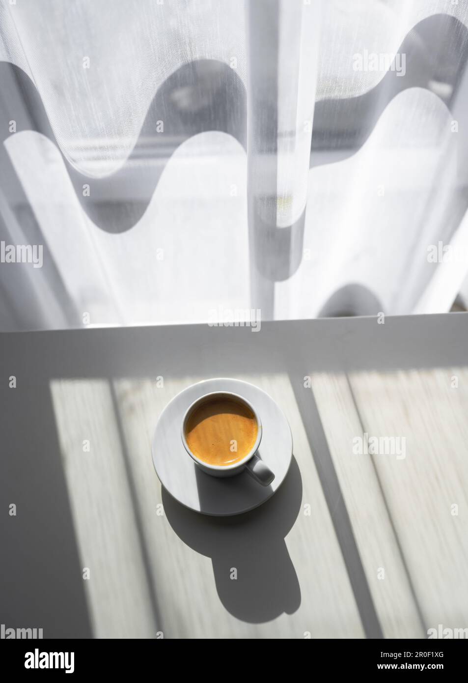 Tasse de café expresso sur table près de la fenêtre avec lumière du matin. Photographie de nourriture et de boissons Banque D'Images