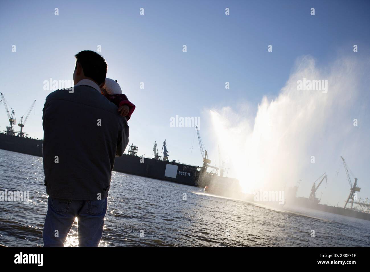 Père tenant bébé, regardant du quai, de la rivière Elbe, du port et des quais, St. Pauli, Hambourg, Allemagne Banque D'Images