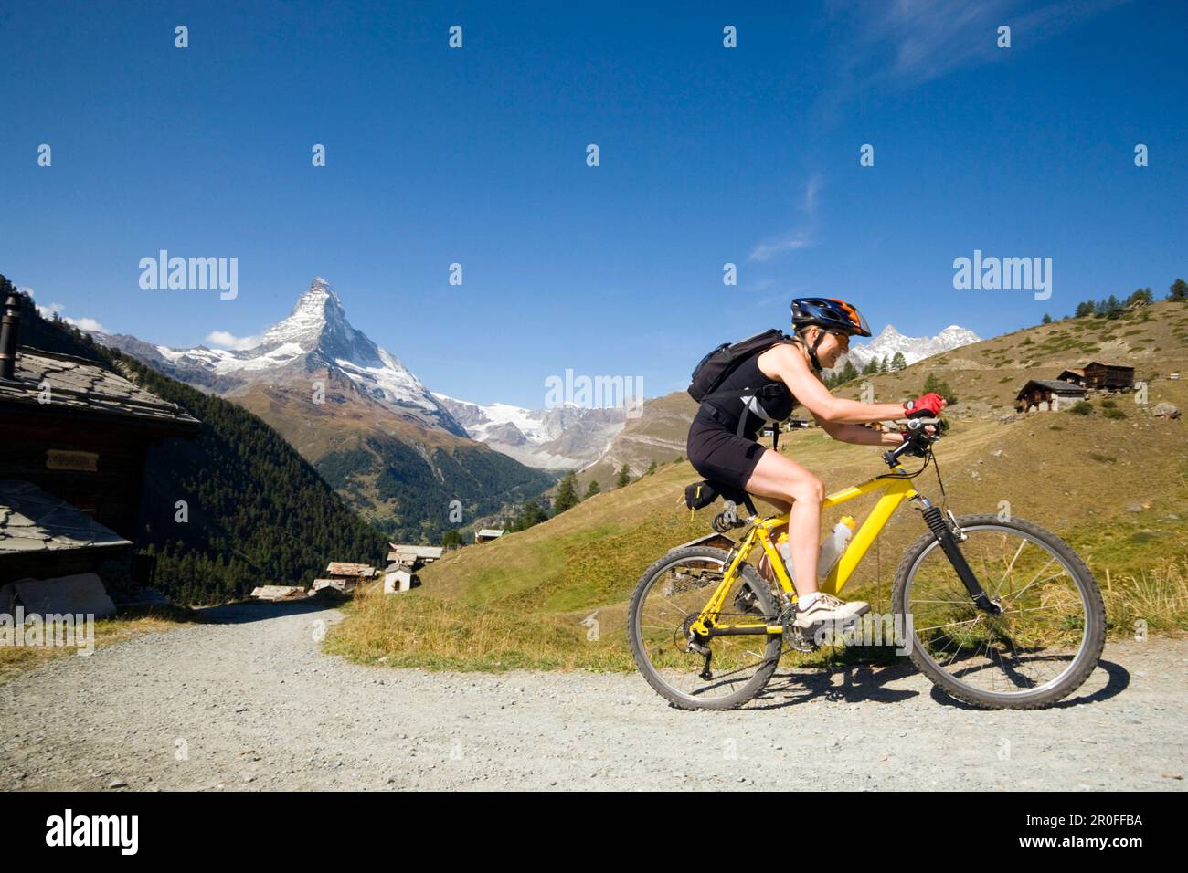 Motard de montagne femelle quittant le village de montagne Findeln, Matterhorn, 4478 m, en arrière-plan, Zermatt, Valais, Suisse Banque D'Images