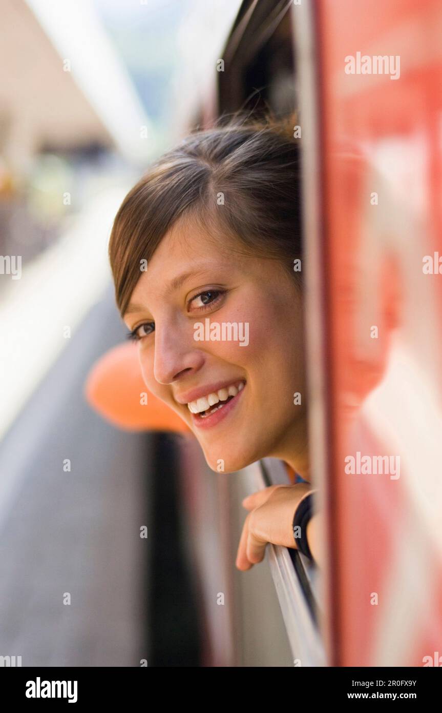 Jeune femme à la recherche d'une fenêtre d'un train vitesse Banque D'Images