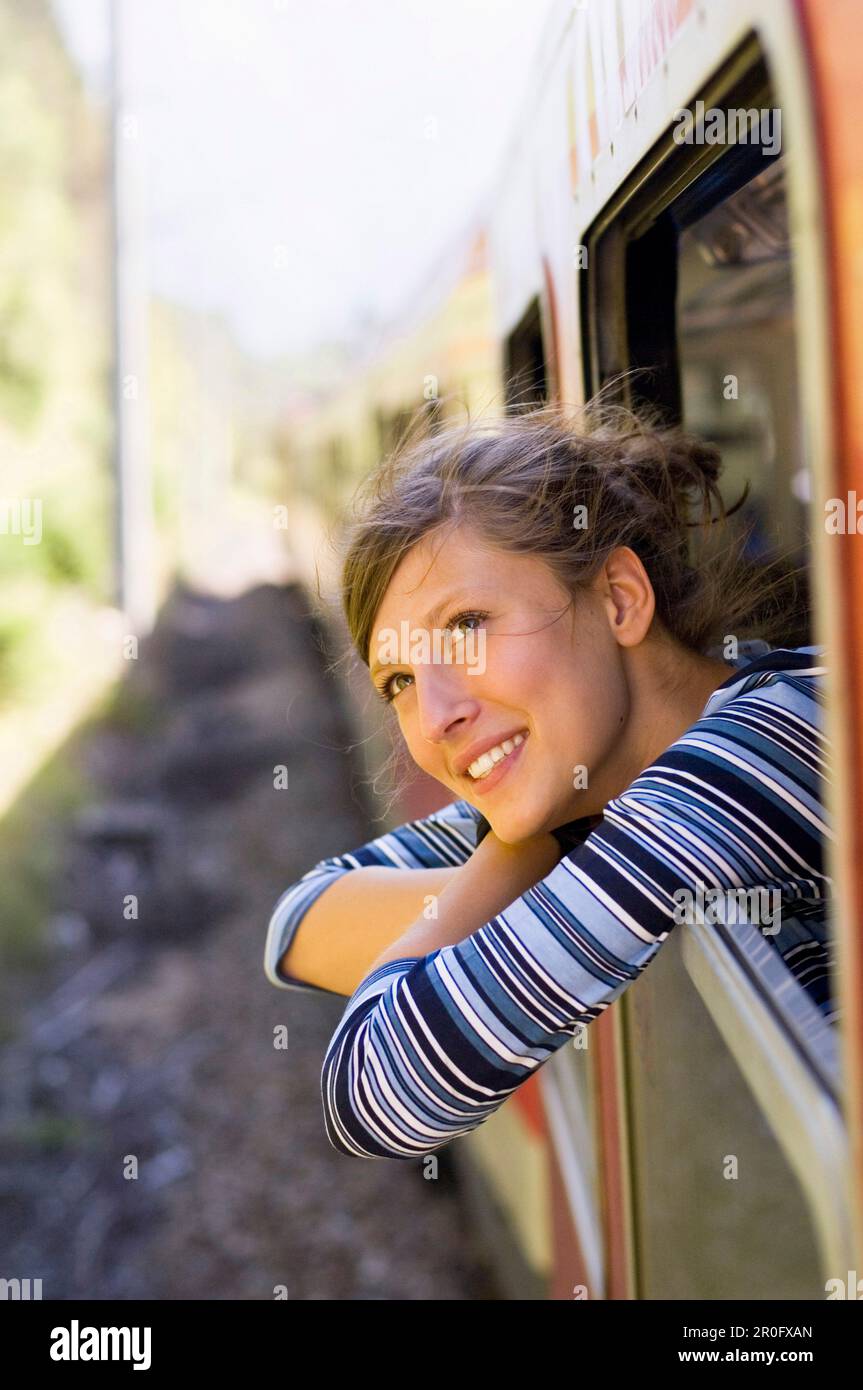 Jeune femme à la recherche d'une fenêtre d'un train vitesse Banque D'Images