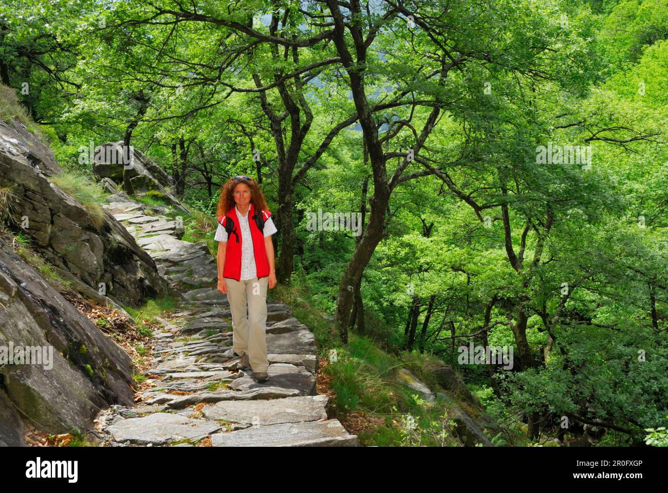 Femme adulte de taille moyenne marchant sur un sentier pavé, Tessin, Suisse Banque D'Images