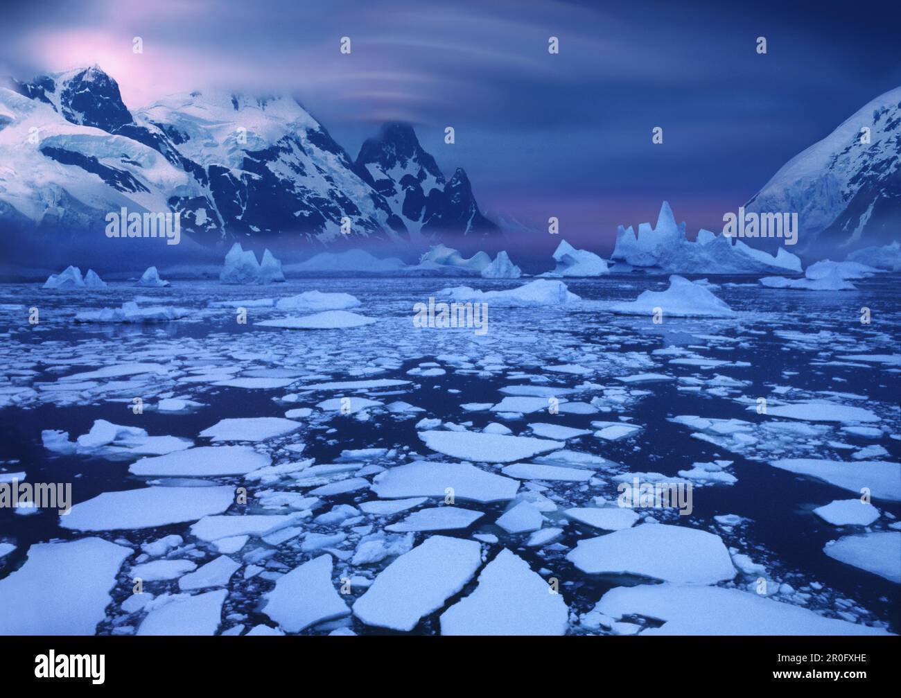 Floes de glace près du cercle antarctique avec des nuages de lenticularis au-dessus du sommet de montagne, péninsule antarctique, Antarctique Banque D'Images