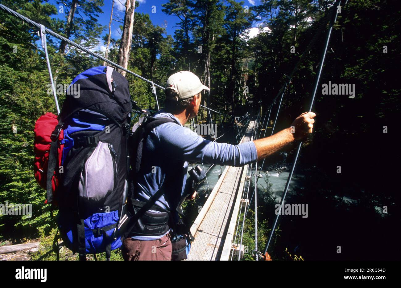 L'homme sur un pont suspendu au-dessus de la rivière Dart Rees, Mount Aspiring National Park, Île du Sud, Nouvelle-Zélande, Océanie Banque D'Images