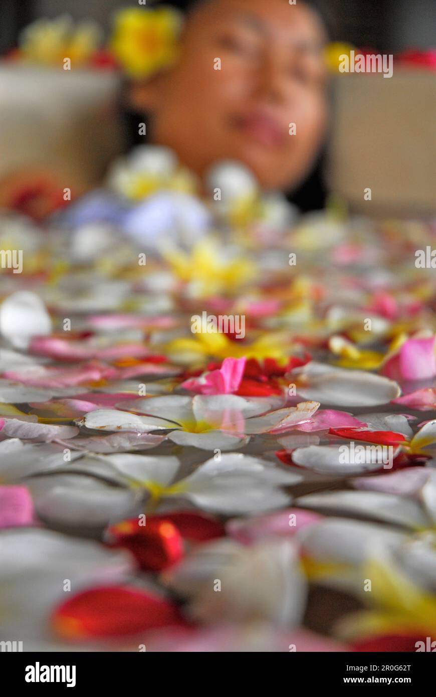 Une femme se baignant dans une baignoire remplie de fleurs, Spa du Chedi Club, GHM Hôtel, Ubud, Indonésie, Asie Banque D'Images