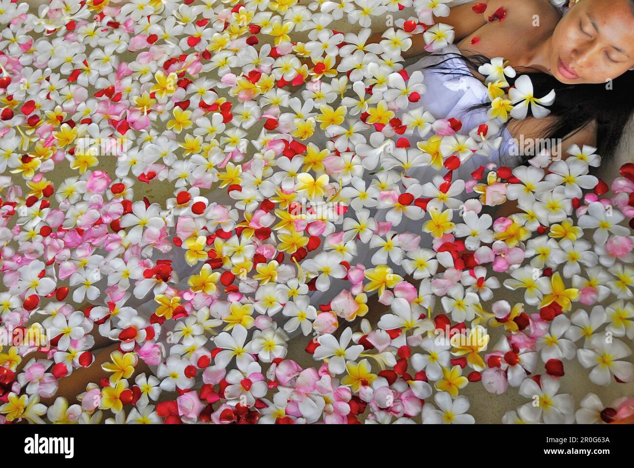 Une femme se baignant dans une baignoire remplie de fleurs, Spa du Chedi Club, GHM Hôtel, Ubud, Indonésie, Asie Banque D'Images