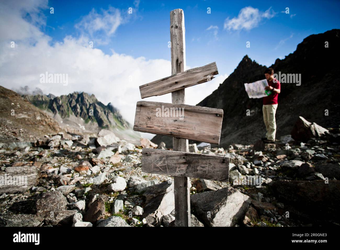 Homme lisant une carte près de signpost, Litzner Sattel, Silvretta, Vorarlberg, Autriche Banque D'Images