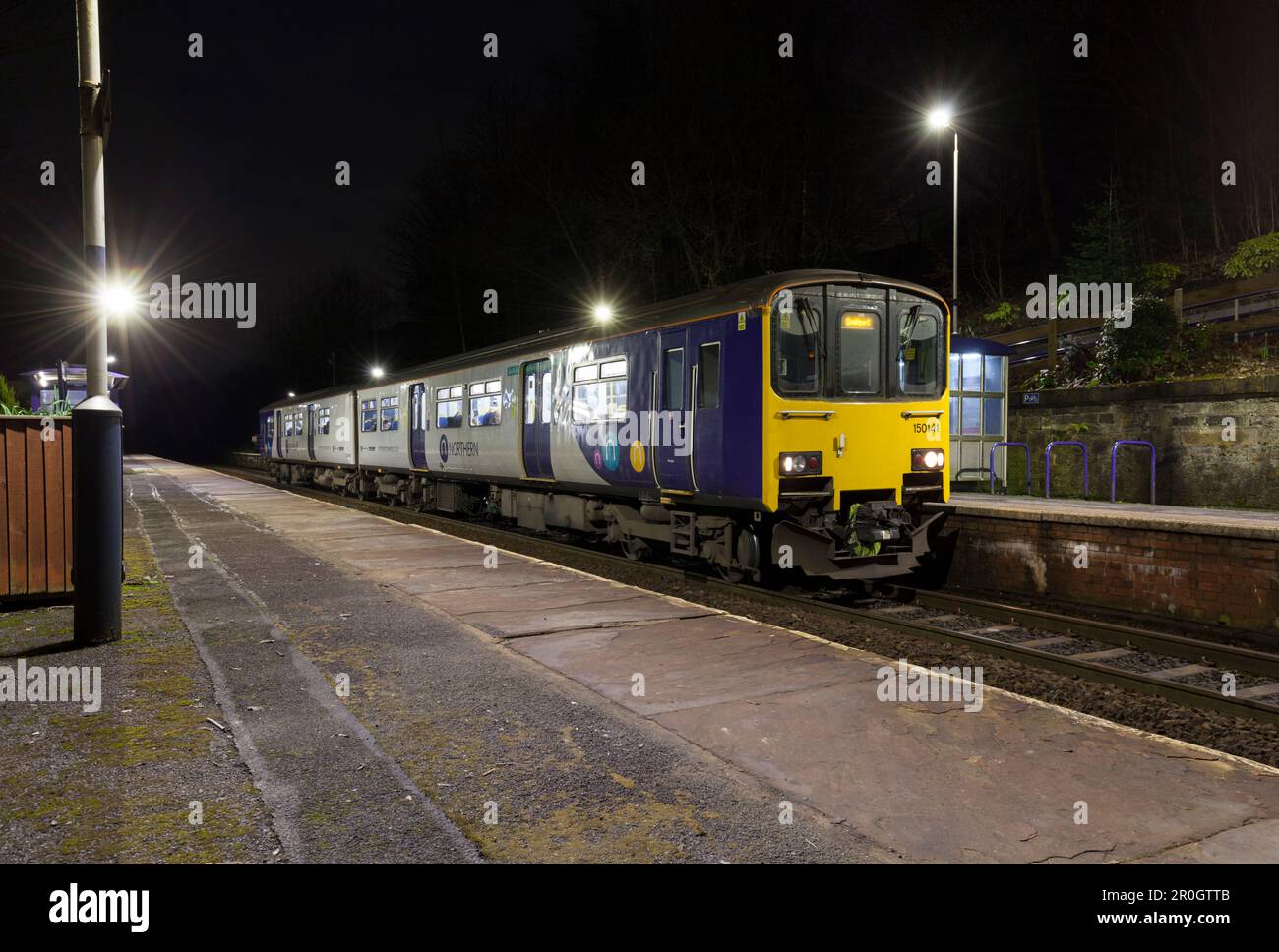 Northern Rail classe 150 train 150141 appelant à la gare de Westhinton pendant une nuit sombre Banque D'Images