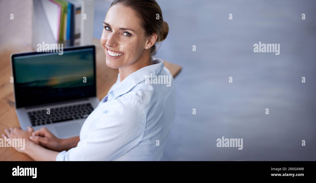 Essayer de voir mon meilleur travail. Prise de vue sur l'épaule d'une femme d'affaires travaillant sur un ordinateur portable. Banque D'Images