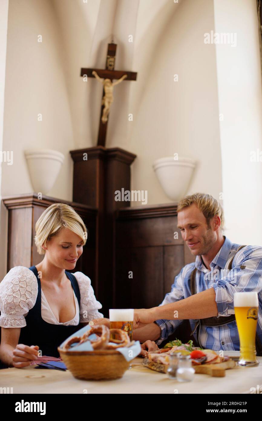 Jeune couple en costumes traditionnels ayant une collation dans un restaurant Banque D'Images