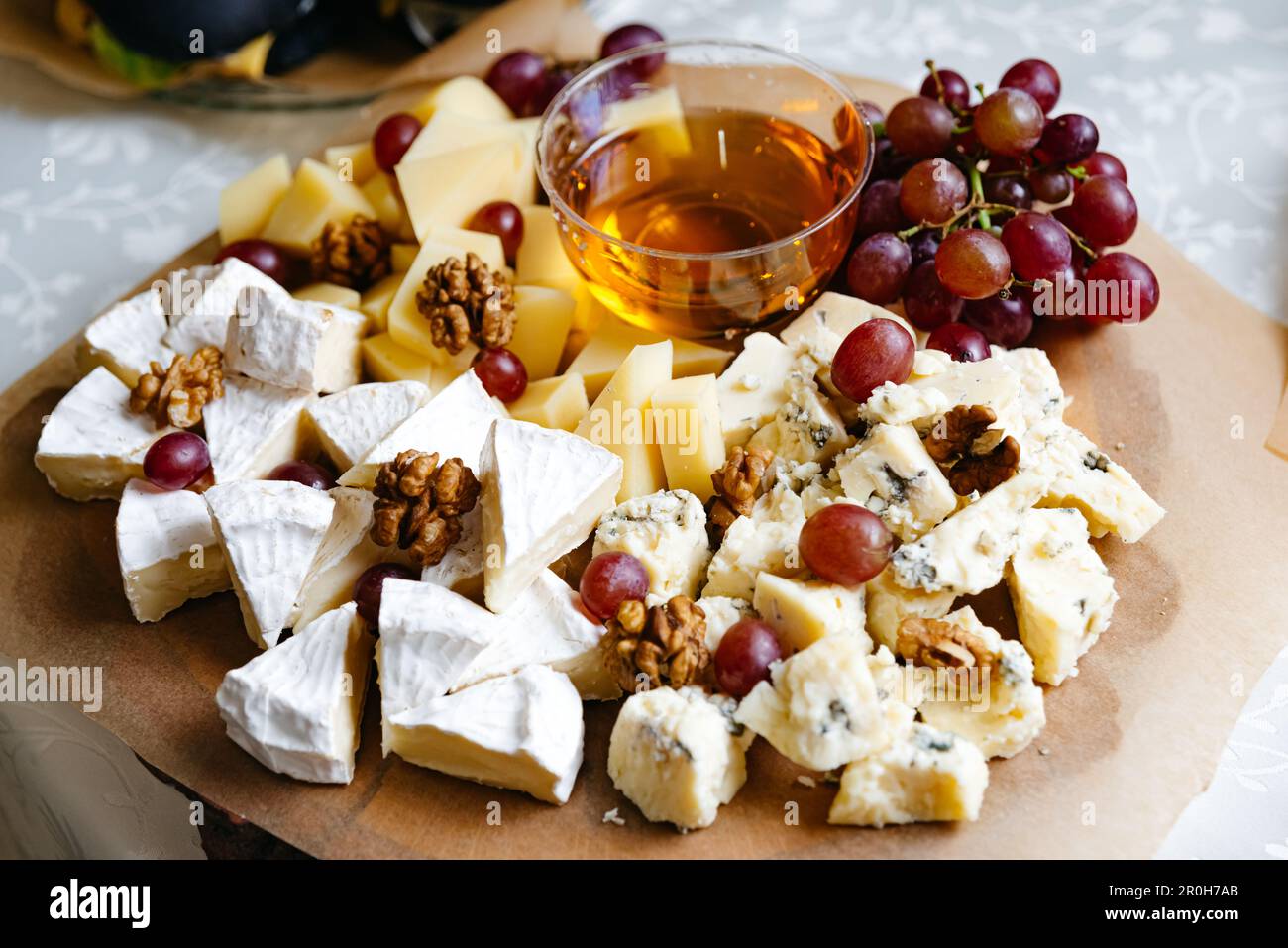 Assortiment de fromages et assiette de fruits. Une variété variée de fromages frais, fruits et noix présentés sur un grand plateau - un hors-d'œuvre sain idéal pour Banque D'Images