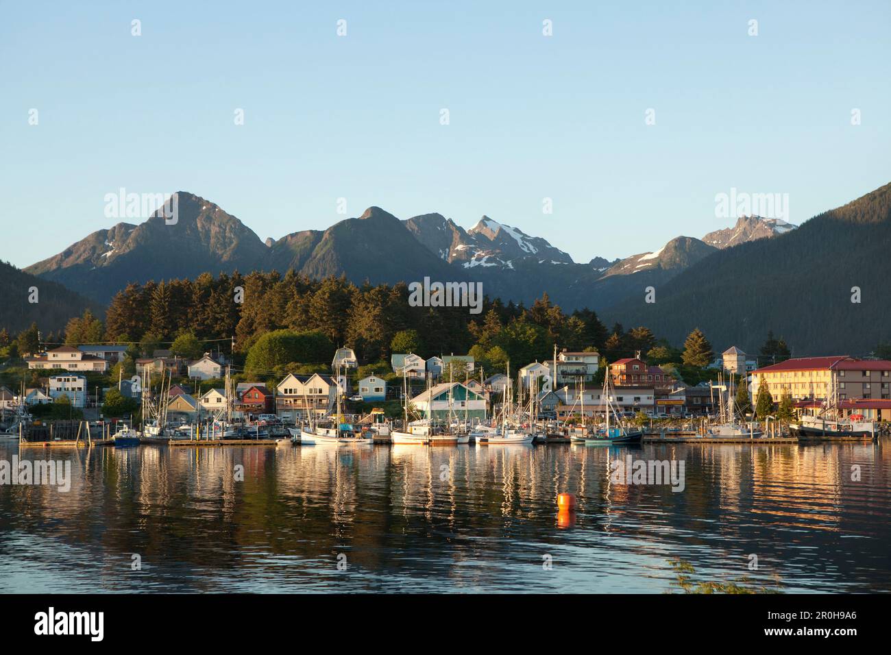 ALASKA, Sitka, une vue paisible des maisons et des bateaux de pêche le long de la rive dans le port de Sitka au coucher du soleil, Crescent Bay Banque D'Images