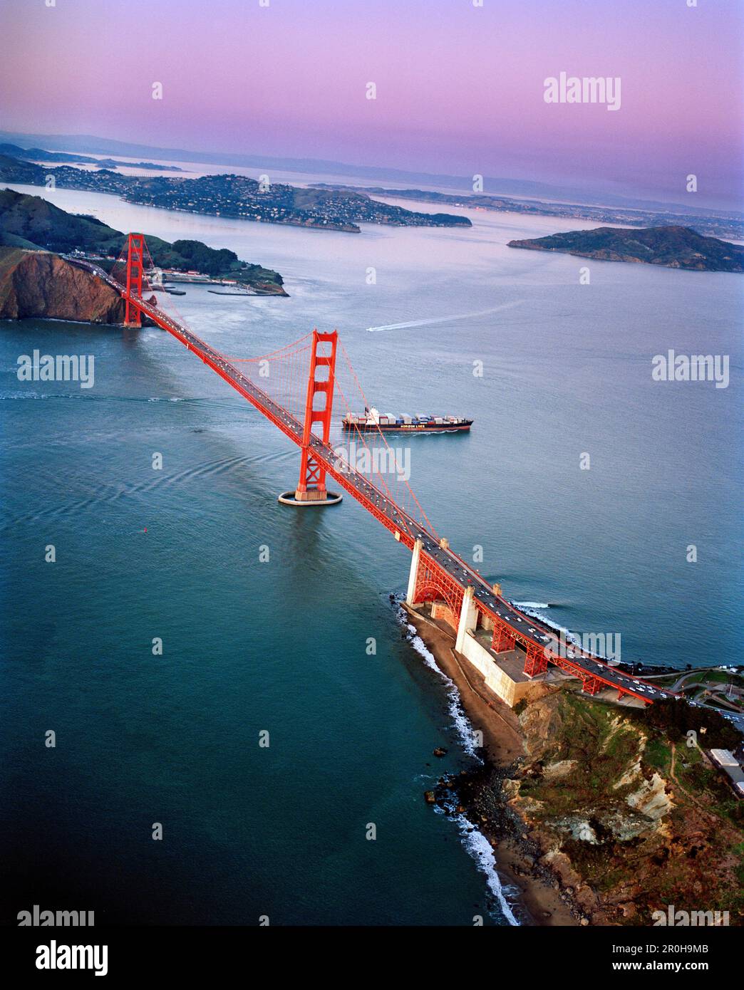 USA, San Francisco, une vue aérienne d'un navire à conteneurs passant sous le Golden Gate Bridge, une vue vers les Marin Headlands, Tiburon et Angel Isl Banque D'Images