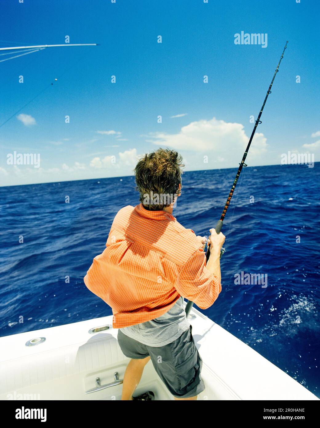 USA, Floride, l'homme de plein fouet dans un poisson en mer, vue arrière, Islamorada Banque D'Images