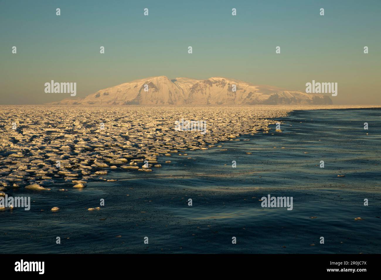 Floes de glace flottant dans la mer formant une ligne le long de la côte, des montagnes enneigées en arrière-plan, Terra Nova Bay, Antarctique Banque D'Images