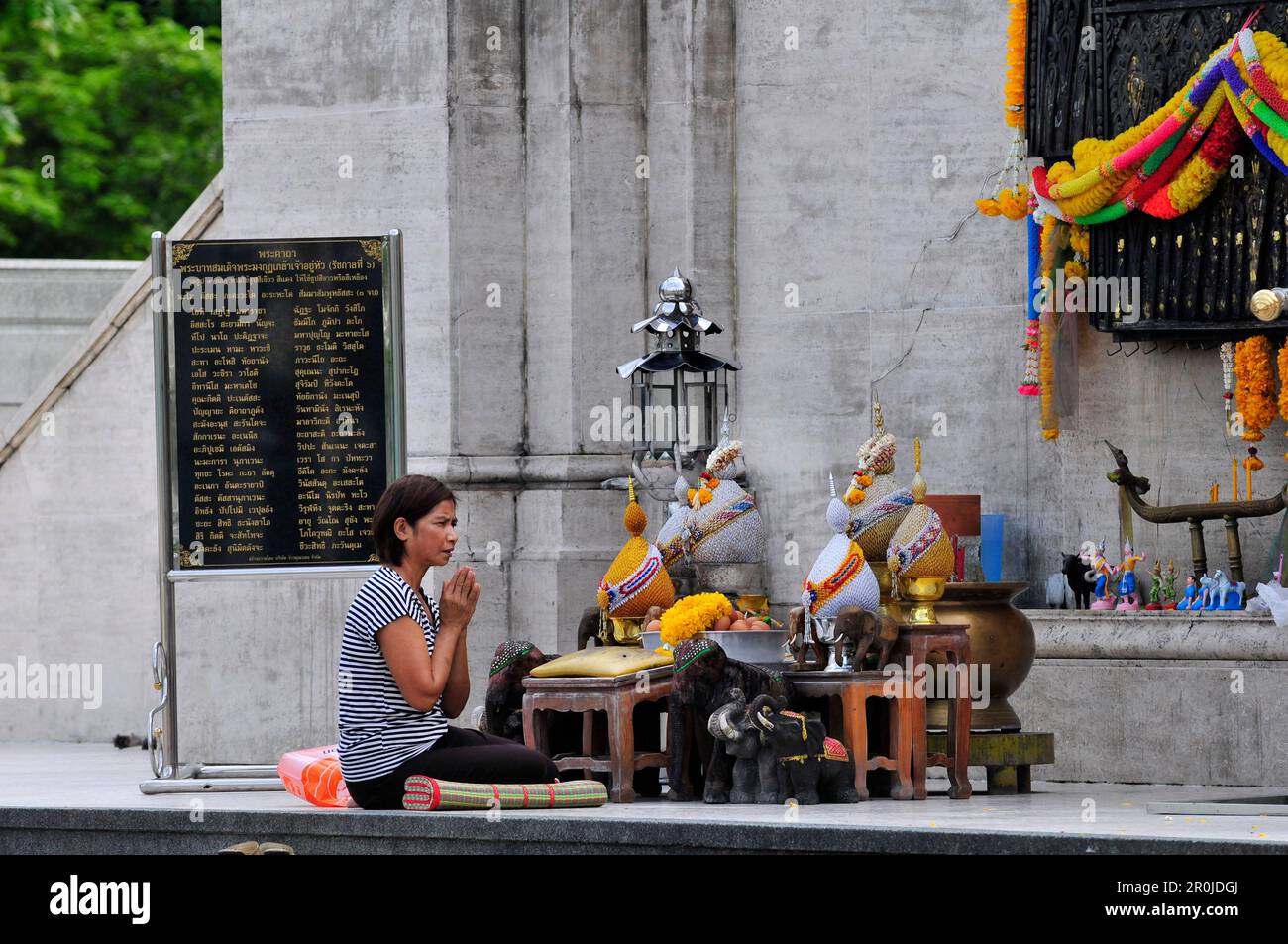 Une femme thaïlandaise priant au monument Roi Rama VI, parc Lumphini, Bangkok, Thaïlande. Banque D'Images