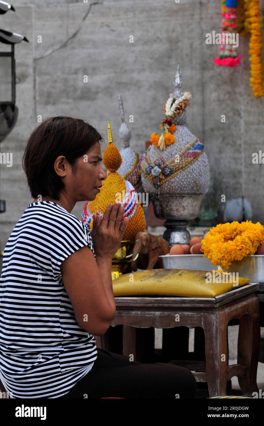 Une femme thaïlandaise priant au monument Roi Rama VI, parc Lumphini, Bangkok, Thaïlande. Banque D'Images