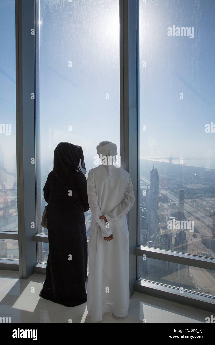 Homme et femme arabes vêtue de vêtements traditionnels Profitez de la vue depuis la terrasse d'observation Top au niveau 124 de la tour Burj Khalifa, Dubaï, Dubaï, AR Banque D'Images