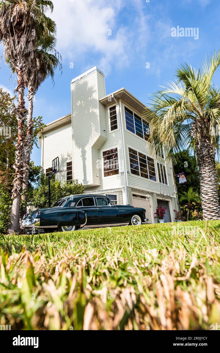 Une Cadillac noire vintage devant une résidence typique de Floride avec palmiers, Miami Beach, Miami, Floride, États-Unis Banque D'Images