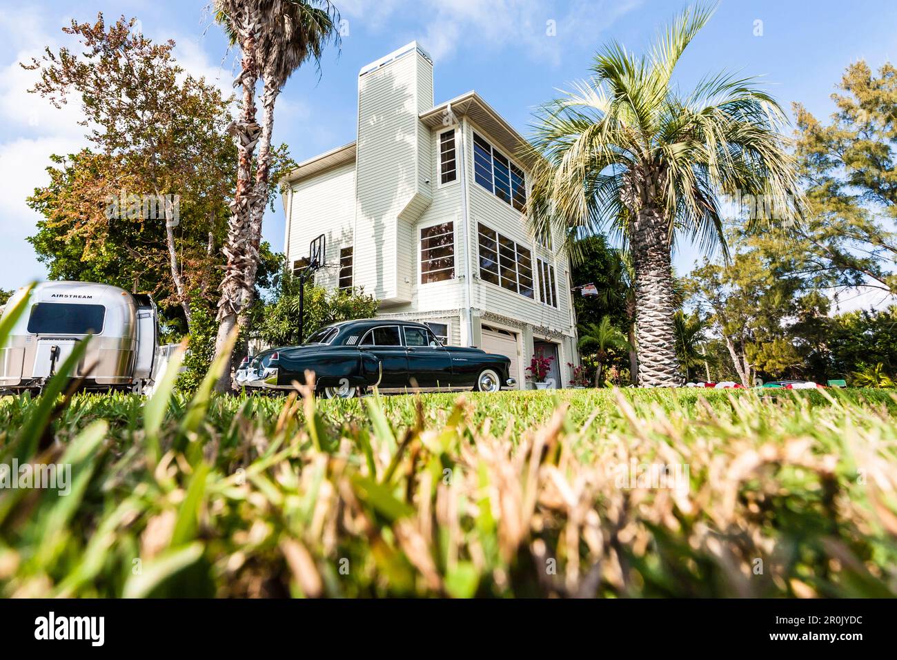Une Cadillac noire vintage et une caravane Airstream argentée vintage devant une résidence typique de Floride avec palmiers, Miami Beach, Miami, Floride, Banque D'Images