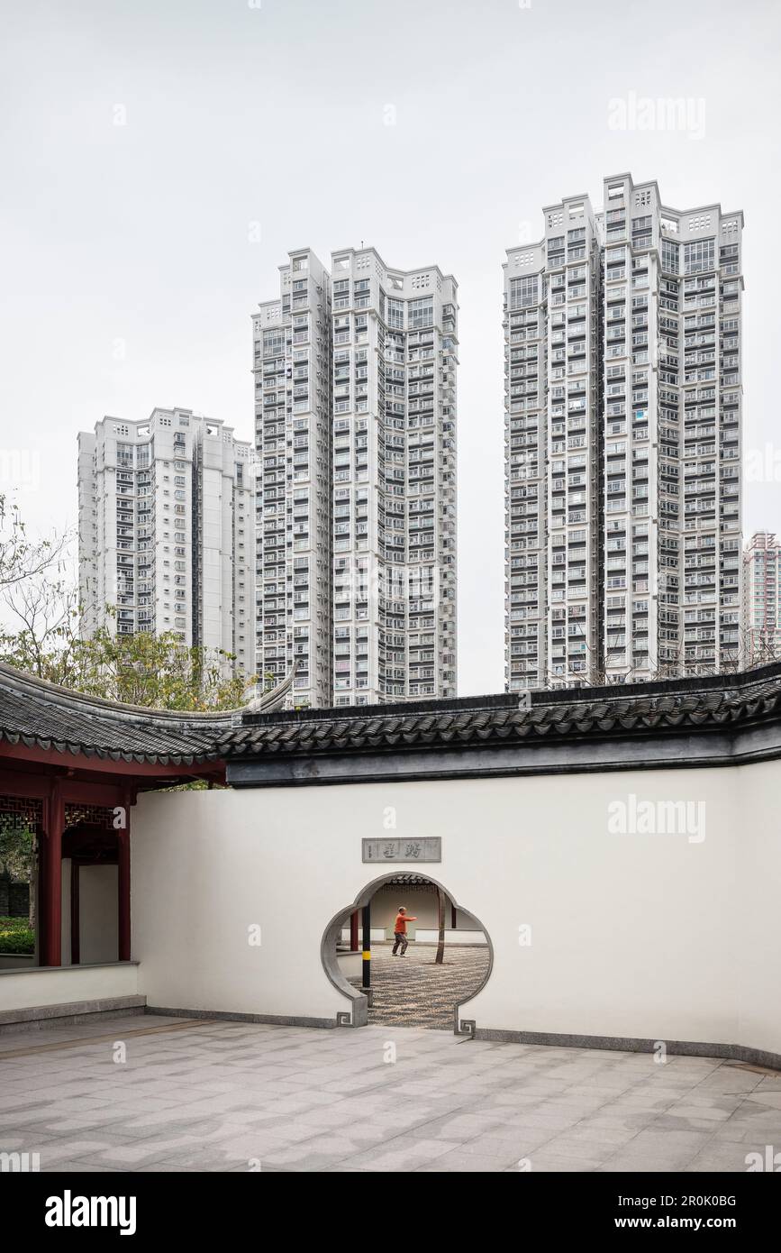 L'ancien homme chinois ne Tai Chia Qigong dans le temple devant le projet moderne de logement, Tin Shu Wai, Hongkong, Chine, Asie Banque D'Images