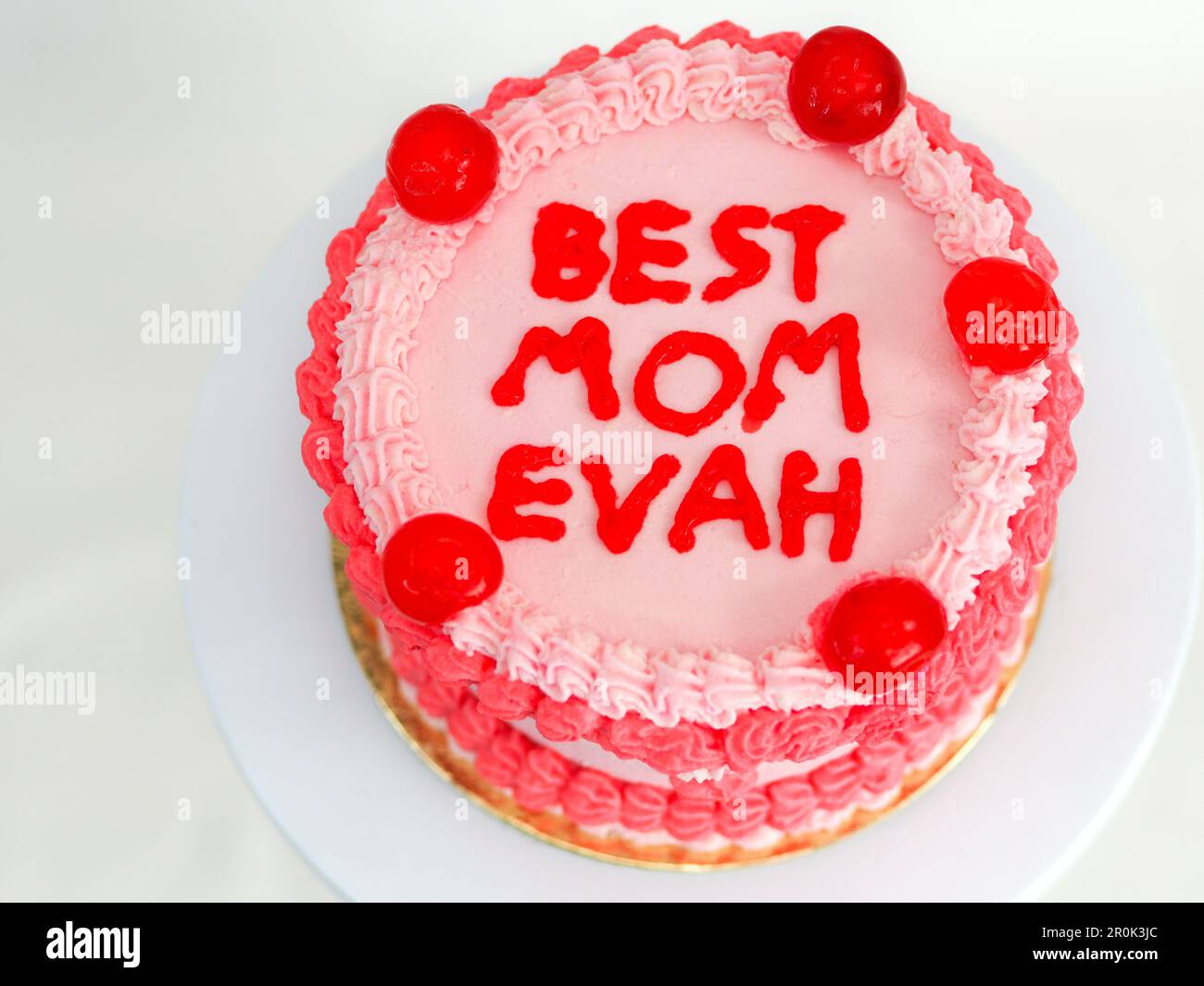 gâteau rouge rose givré pour la fête des mères avec un texte amusant garniture meilleure maman evah sur fond blanc studio Banque D'Images