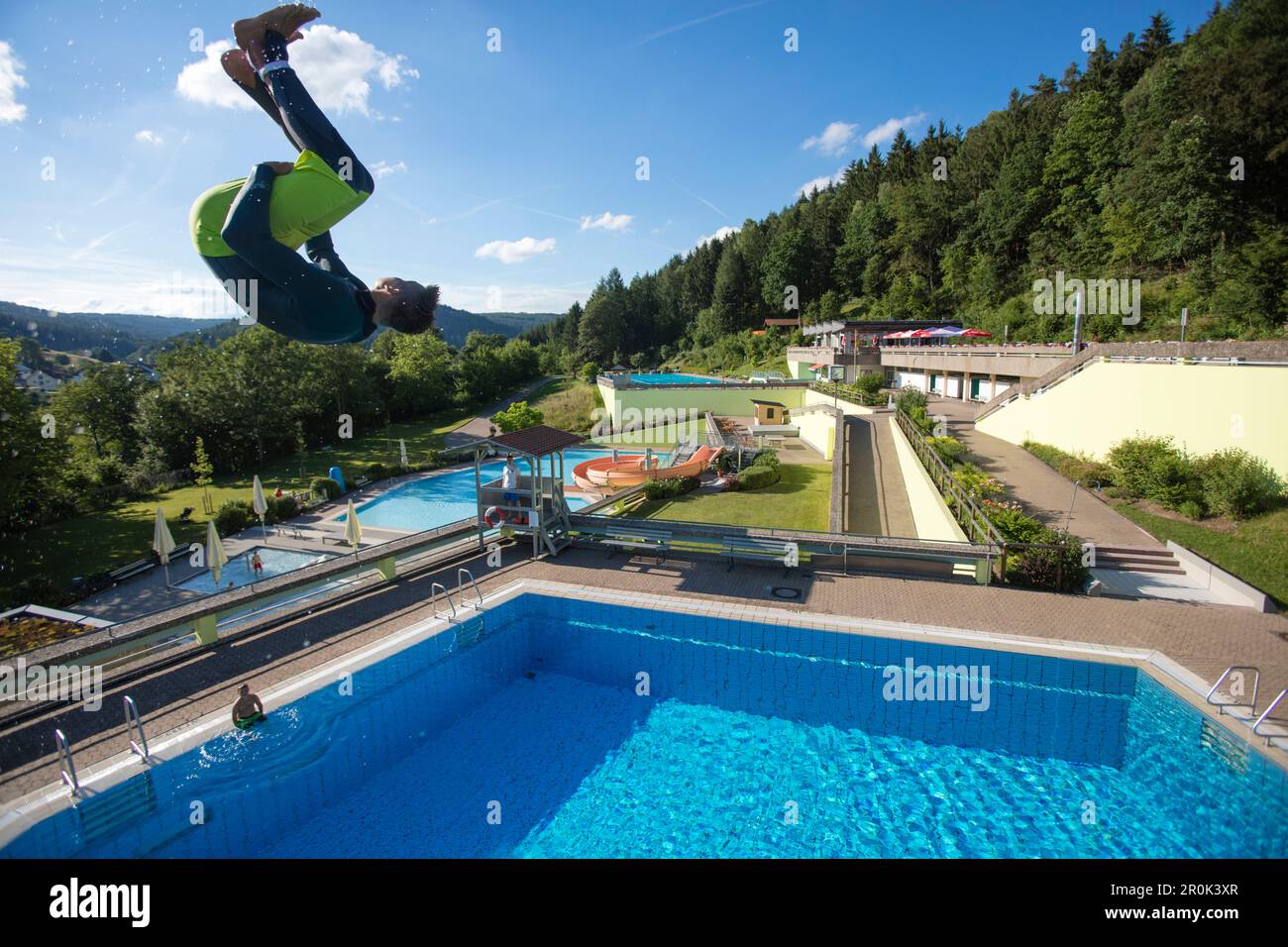 Un jeune homme saute de 5 mètres de tour de plongée dans la piscine à Freibad Terrassenbad Frammersbach, Frammersbach, Spessart-Mainland, Bavière, Allemagne Banque D'Images