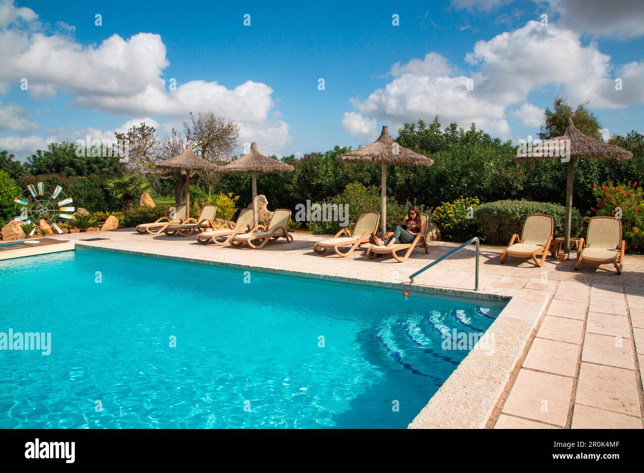 Une jeune femme se détend au bord de la piscine à l'hôtel Agroturisme sa Carrotja finca, ses Salines, Majorque, Iles Baléares, Espagne Banque D'Images