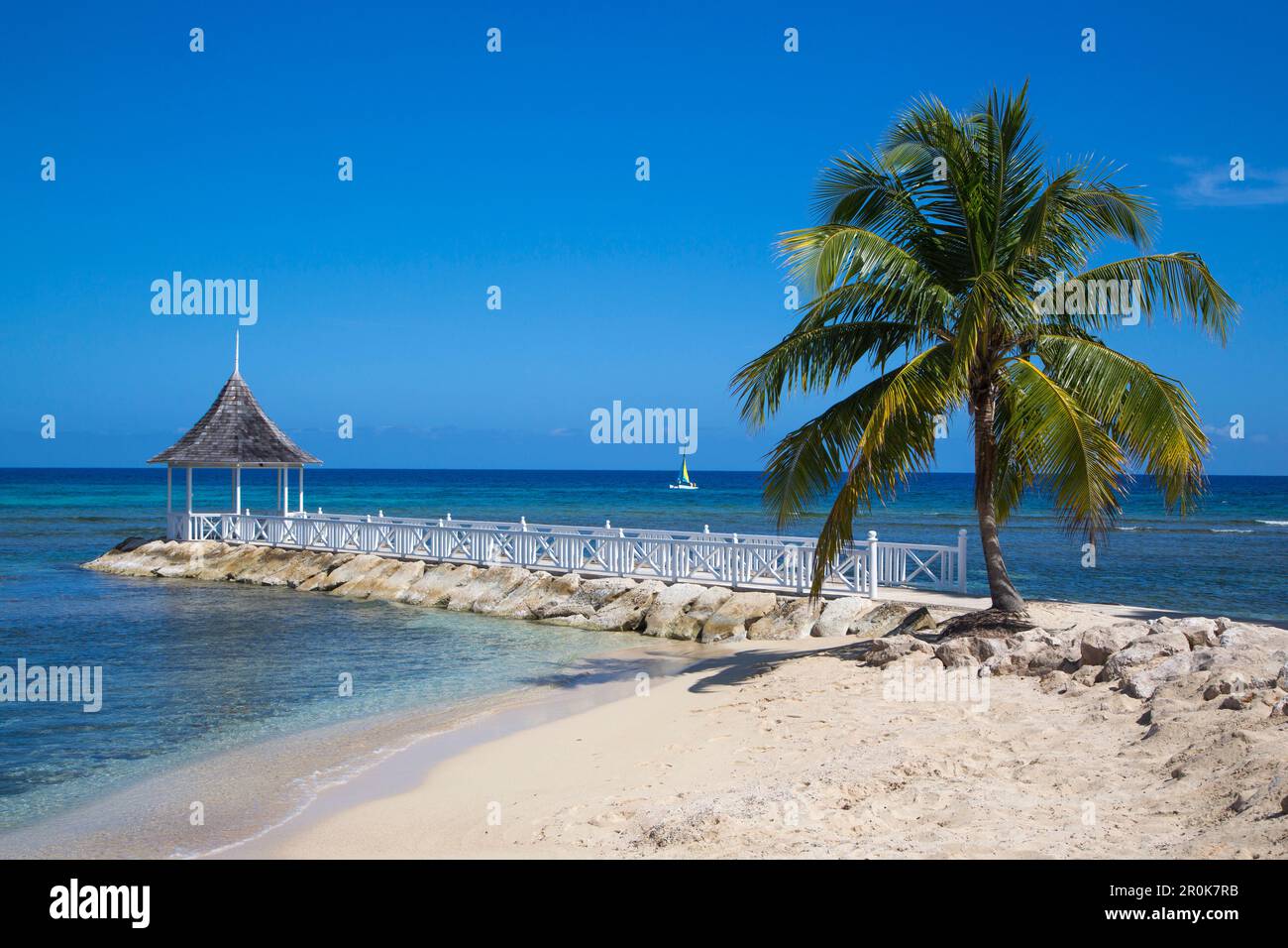 Sunset Beach et jetée avec pavillon à Half Moon Resort avec voilier Hobie Cat dans Caribbean Sea Rose Hall, près de Montego Bay, Saint James, Jamaïque Banque D'Images