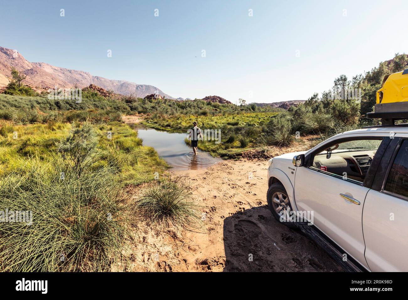 Avant de traverser la rivière Ugab de Kunenen à Erongo, le chauffeur vérifie la profondeur de l'eau. En arrière-plan la montagne Brandberg, Erongo, Damaraland Banque D'Images