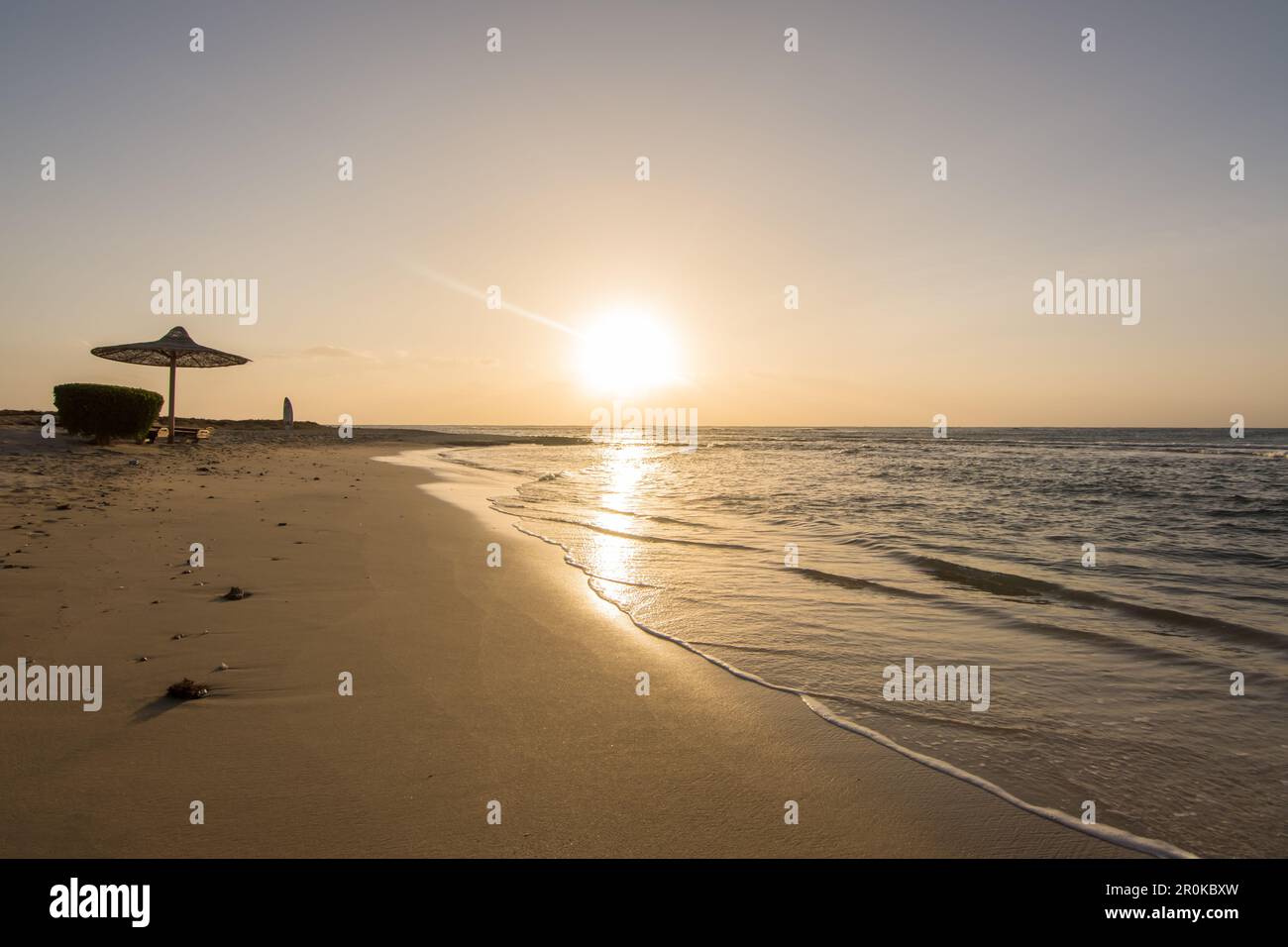magnifique lever de soleil sur la plage de sable avec un parasol à la mer en egypte Banque D'Images