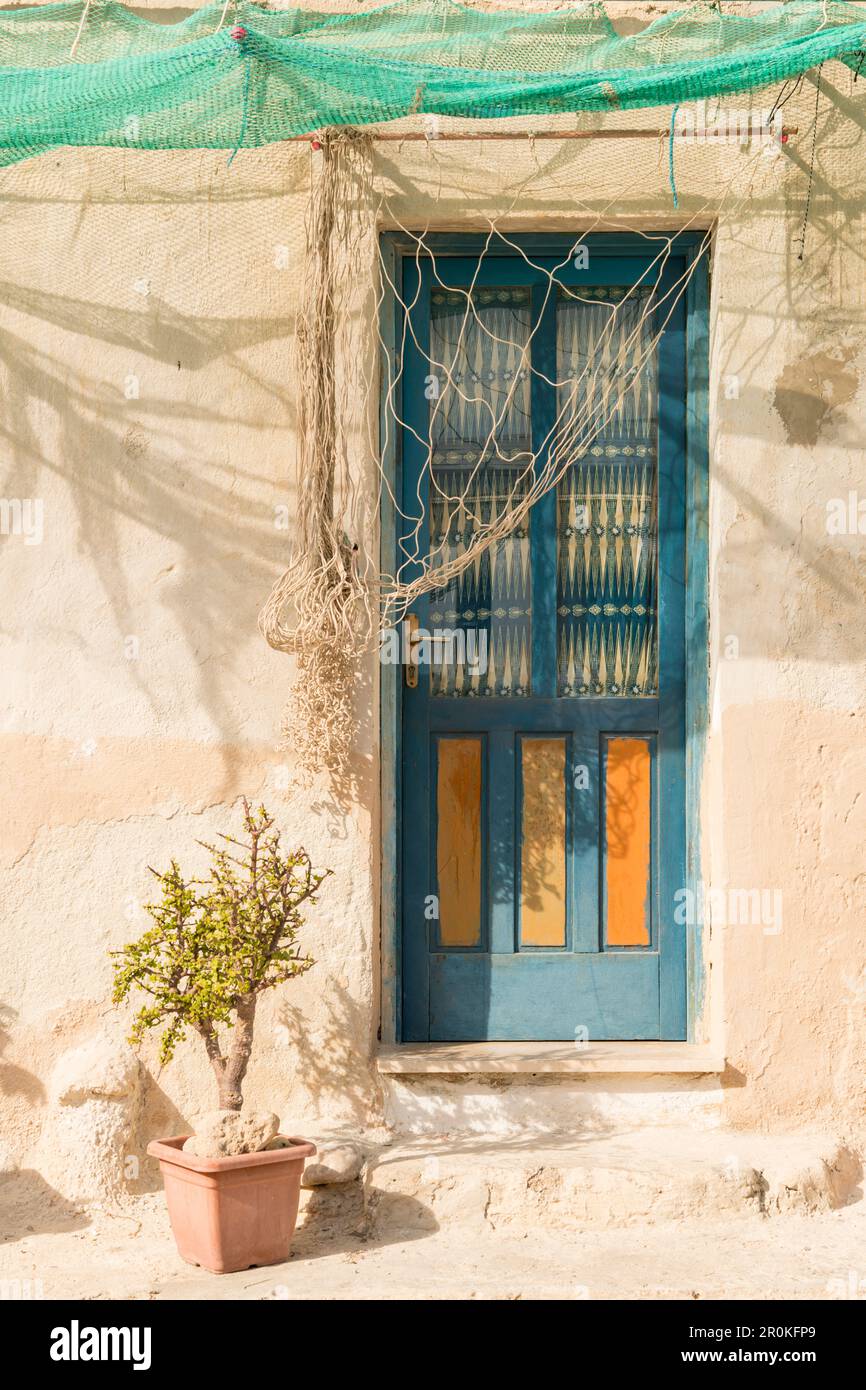 Porte bleue avec filets de pêche comme ombrage, île Levanzo, îles Aegadiennes, près de Trapani, Sicile, Italie, Europe Banque D'Images