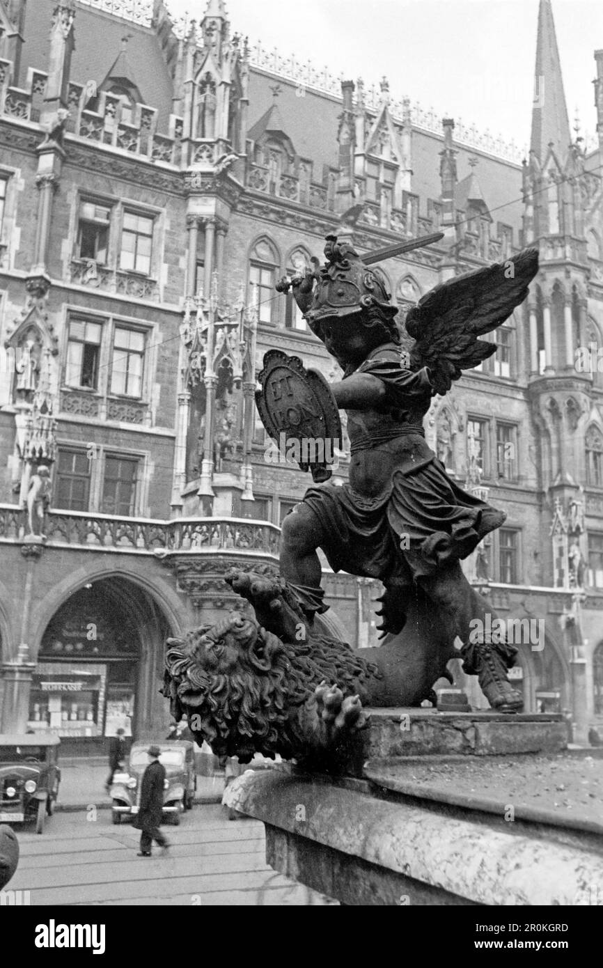 Eine der vier Heldenputten auf dem Sockel der Mariensäule auf dem Münchner Marienplatz, dieser bekämpft einen Löwen, der als Metapher für Krieg steht, 1936. Un des quatre putti héroïques sur la base de la colonne Mariale sur la Marienplatz de Munich, celui-ci battant un lion, une métaphore de la guerre, 1936. Banque D'Images