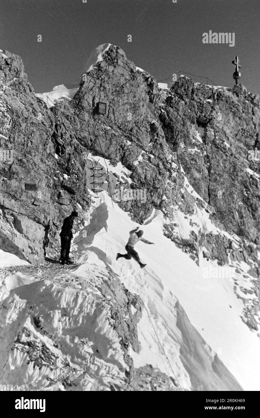 Ein Mann springt in eine Schneewehe auf dem Gipfel der Zugspitze, 1936. Un homme saute dans une dérive des neiges sur le sommet du Zugspitze, 1936. Banque D'Images