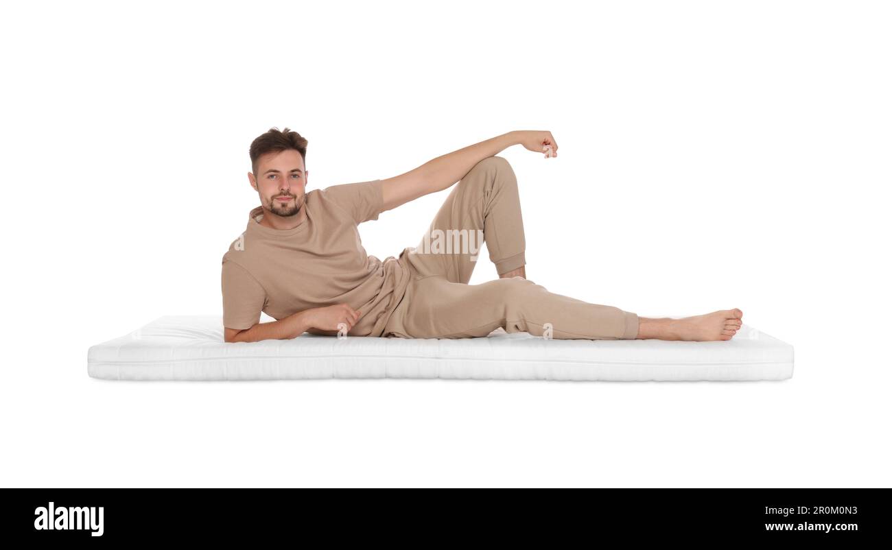 Homme allongé sur un matelas doux sur fond blanc Banque D'Images