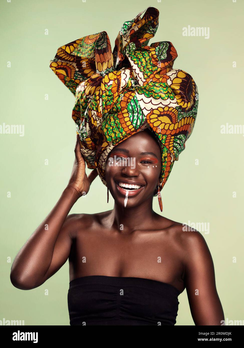 Beauté, femme noire et portrait avec foulard africain et sourire dans un studio. Isolé, vert fond traditionnel Afrique envelopper avec une jeune femme Banque D'Images