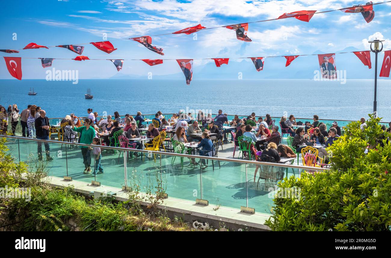 Les gens s'assoient sous des banderoles nationalistes et bénéficient d'une vue panoramique sur la baie et le port depuis un café en plein air situé sur les murs anciens environnants Banque D'Images